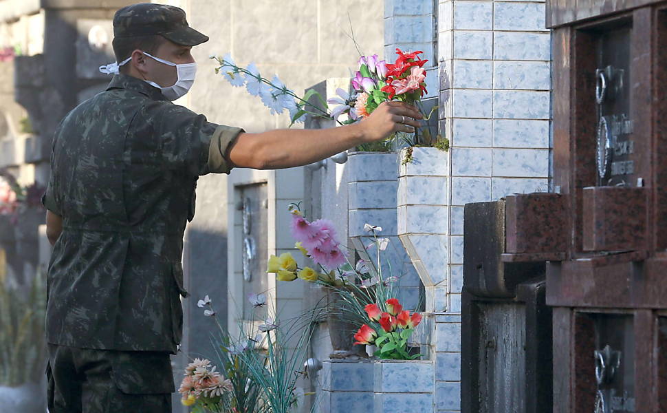 Soldado deixa flores durante velório de uma das vítimas de incêndio em casa noturna são velados em ginásio de Santa Maria, no RS | Marcelo Sayão - 28.jan.13/Efe